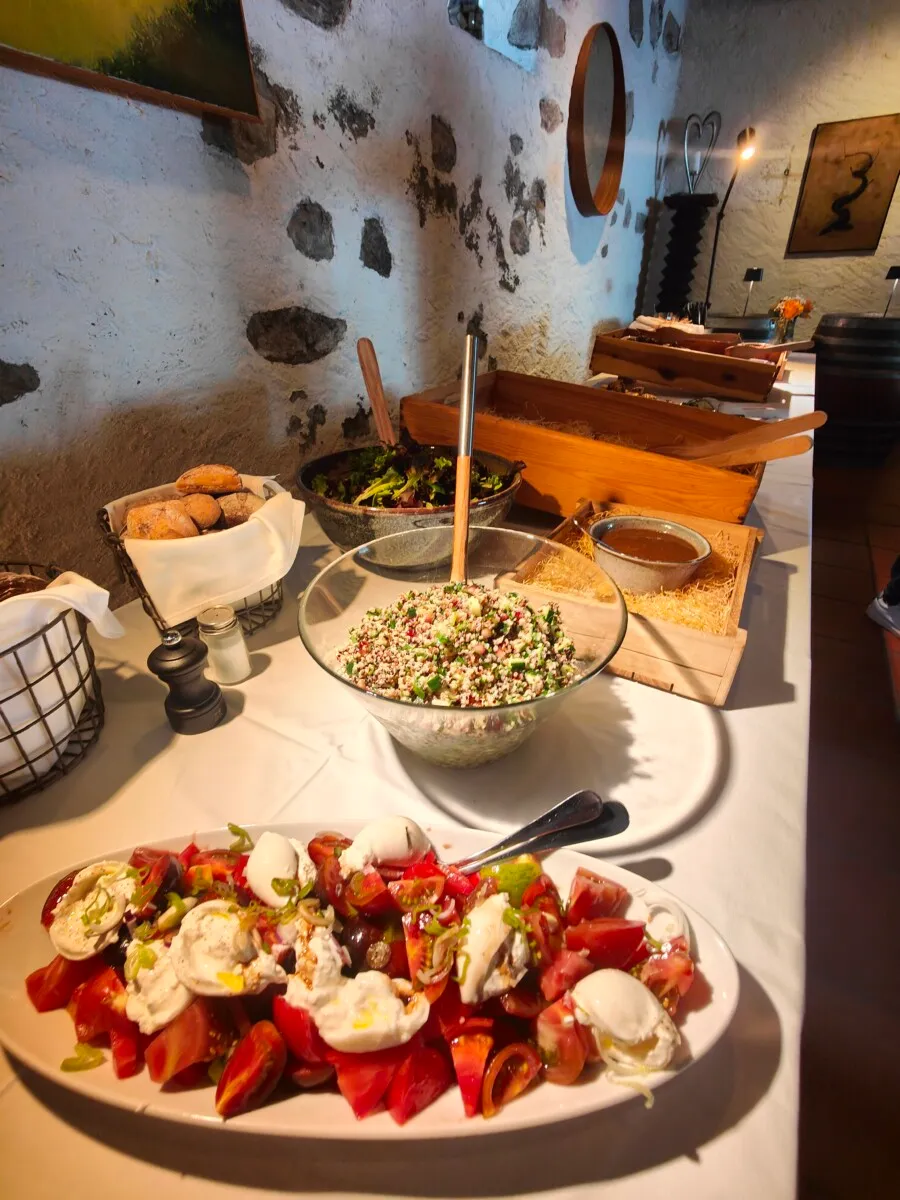 Salatbuffet mit verschiedenen Speisen in einem rustikalen Weinkeller