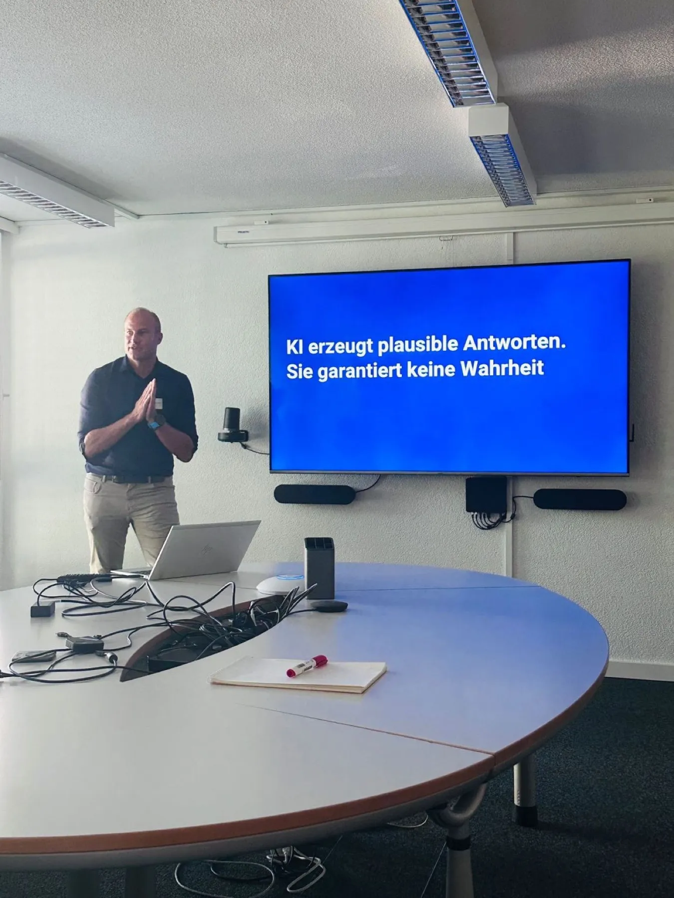 Fabian Rezzonico leitet einen Workshop, auf dem Bildschirm: «KI erzeugt plausible Antworten. Sie garantiert keine Wahrheit»